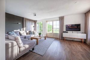 a living room with a couch and a tv at Dutchen Waddenduyn in Den Burg