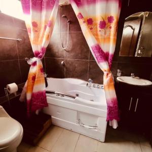 a bathroom with a tub and a toilet and a sink at Departamento amplio y lujoso - excelente ubicación in Quito