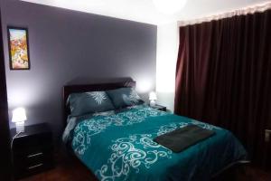 a bedroom with a bed with a green and white bedspread at Departamento amplio y lujoso - excelente ubicación in Quito