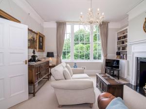 a living room with white furniture and a chandelier at Pass the Keys High Spec 2 Bedroom Apartment with a View in Great Malvern