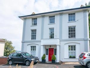 a white house with a red door at Pass the Keys High Spec 2 Bedroom Apartment with a View in Great Malvern