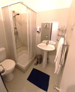een badkamer met een douche, een toilet en een wastafel bij HI Ponte de Lima - Pousada de Juventude in Ponte de Lima