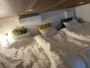 ein großes weißes Bett in einem Zimmer in der Unterkunft HoshinoHana ~ Beach house~ in Hirakubo