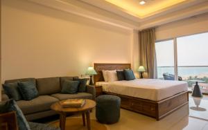 a hotel room with a bed and a couch at Sea Breeze Heaven Residencies By Cocotech in Negombo +48 photos