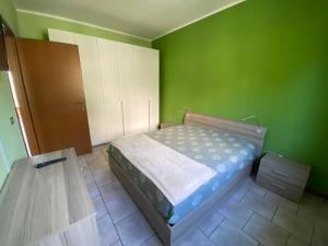 um quarto com uma cama e uma parede verde em LEMON House em Ventimiglia
