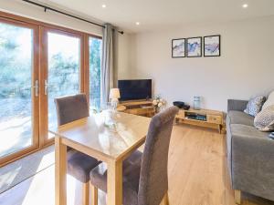 sala de estar con mesa de madera y sillas en Host & Stay - Oak Barn, en Ashford