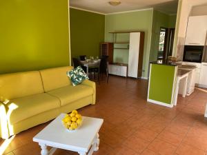 uma sala de estar com um sofá amarelo e uma mesa em LEMON House em Ventimiglia