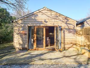 un pequeño cobertizo de madera con una puerta abierta en Host & Stay - Oak Barn, en Ashford