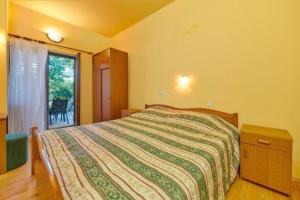 a bedroom with a bed and a window at Apartments Davorka in Banjole