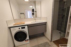 W łazience znajduje się pralka i umywalka. w obiekcie Villa T3 climatisée en résidence avec piscine w mieście Vias