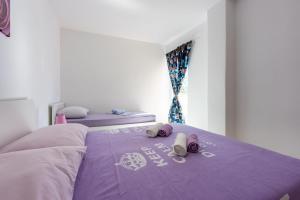 a purple bed with two pillows on top of it at Apartments Davor in Banjole