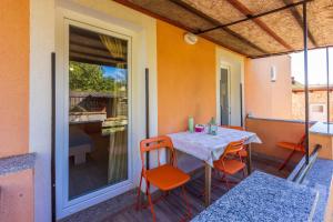 a patio with a table and chairs on a balcony at Apartments Davor in Banjole