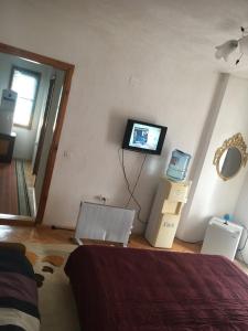 um quarto com uma cama e uma televisão na parede em Rooms Struga em Struga