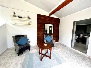 ein Wohnzimmer mit 2 Stühlen und einem Tisch in der Unterkunft Eagles Rest Cottage in Margate