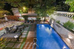 Una piscina en un patio trasero por la noche. en EKO STAY- Villa BLANCO, en Lonavala