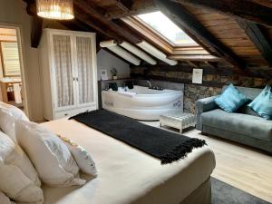 LastrasにあるAkla Hotel Palacio Torre de Ruesgaのベッドルーム(バスタブ、ベッド、ソファ付)
