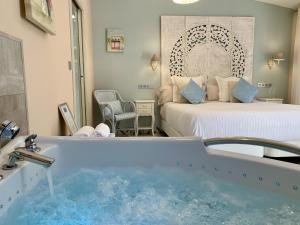 um quarto de hotel com uma banheira e uma cama em Akla Hotel Palacio Torre de Ruesga em Lastras