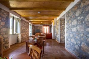 une salle à manger avec un mur en pierre, des tables et des chaises dans l'établissement Casa D'alunzio - appartamento 1, à San Marco dʼAlunzio