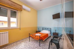 um quarto com uma cama e uma cadeira e uma televisão em Casa D'alunzio - appartamento 1 em San Marco dʼAlunzio