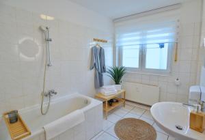 een badkamer met een bad en een wastafel bij TIMELESS APARTMENT: FREE PARKING + BALCONY in Wuppertal +17 foto's