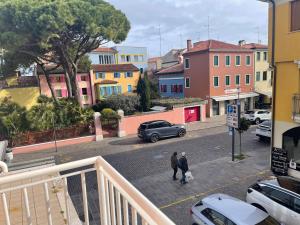 two people walking down a city street with a car at PETRONIA TRILO VISTA MARE - Agenzia Cocal in Caorle