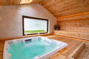 a large bath tub in a room with a window at Maison Rosset agriturismo, camere, APPARTAMENTI e spa in Valle d'Aosta in Nus