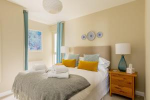 a bedroom with a bed with yellow and blue pillows at About Tern in Poole