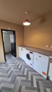 a laundry room with a washer and dryer in a room at Jasper's by Spires Accommodation a great base to stay for Alton Towers and corporate clientele working away from home in Stoke on Trent