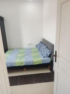 ein kleines Bett in einem Zimmer mit einer Tür in der Unterkunft Baba Residence in Oran