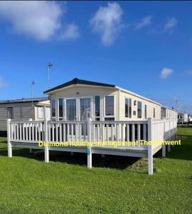 een huis met een witte veranda en een hek bij The Derwent in Prestatyn