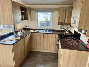 a kitchen with wooden cabinets and a sink at The Derwent in Prestatyn