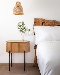 a table with a plant on it next to a bed at Hotel Boutique Mi Almazara in Jávea