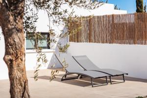 a chair sitting next to a tree next to a fence at Hotel Boutique Mi Almazara in Jávea