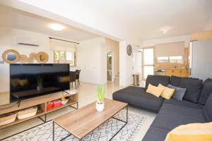 a living room with a couch and a large tv at Villa Oasis in Protaras