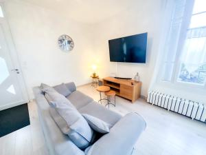 a living room with a couch and a flat screen tv at Bel appartement à 10 minutes de Disney in Quincy-Voisins