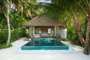 eine Villa mit einem Pool und einem Resort in der Unterkunft Huvafen Fushi in Nord-Malé-Atoll