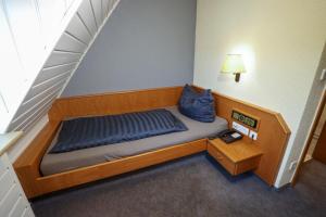 ein kleines Bett in einem Zimmer mit einer Treppe in der Unterkunft Hotel Garni KAMBEITZ in Ötigheim