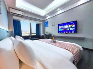een slaapkamer met een groot bed en een flatscreen-tv bij Guangzhou Xing Yi International Apartment Hotel - Vertical City Branch in Guangzhou