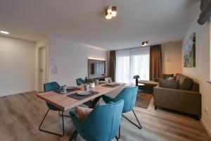 ein Wohnzimmer mit einem Tisch und blauen Stühlen in der Unterkunft Ferienwohnungen Stock Ferienwohnung Nr 4 in Friedrichshafen