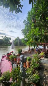 a table with potted plants next to a body of water at ทับทิมทอง โฮมสเตย์ in Ban Khlong Khut