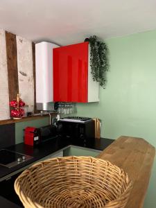 a kitchen with a black counter and red cabinets at Les Petits Apparts Versailles in Versailles