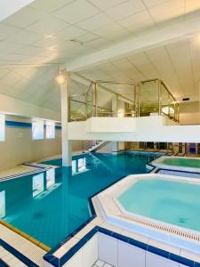 - une grande piscine d'eau bleue dans un bâtiment dans l'établissement Résidence Le Grand Tétras- SPA THERMAL INCLUS, à Ax-les-Thermes