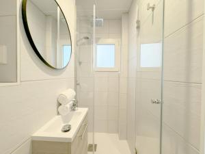 ein Bad mit einer Dusche, einem Waschbecken und einem Spiegel in der Unterkunft Luminoso, cómodo y buena zona in Madrid