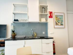 a kitchen with white cabinets and a sink at Luminoso, cómodo y buena zona in Madrid
