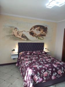 1 dormitorio con 1 cama con una pintura en la pared en Maryhouse en Venegono Superiore
