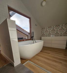 a large white tub in a bathroom with a window at BoxHome Navafría in Navafría