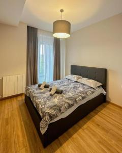 a large bed in a bedroom with a large window at Suites In Tbilisi Hilton Apartment in Tbilisi City