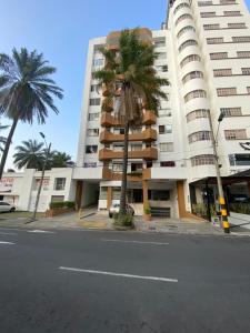 a large building with a palm tree in front of it at Apartarstudio muy bien ubicado, cercano a todo!! in Cali