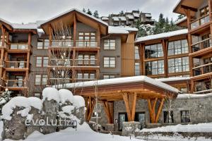 a large apartment building with snow on the ground at Evolution Whistler, by Lodging Ovations in Whistler