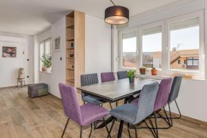 a dining room with a table and purple chairs at Bells & Whistles, Comfortable Condo in Split